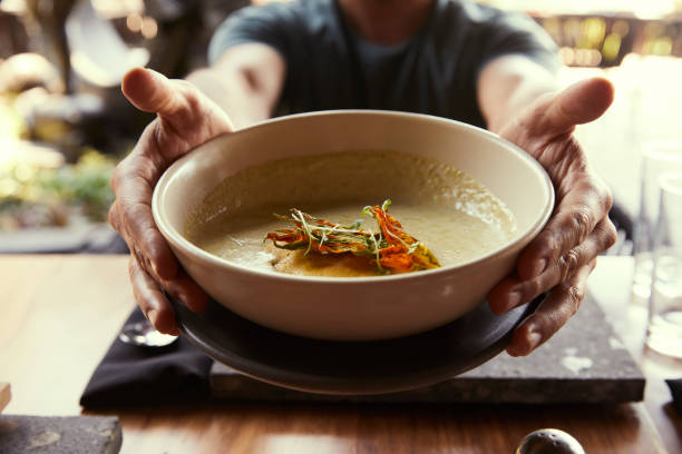 Hands holding a bowl of nourishing soup